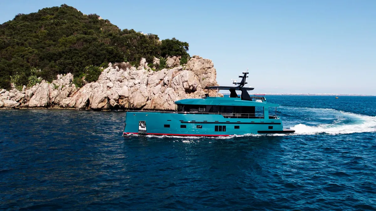 Bering Yachts B78: Turquoise jacht vaart langs kust