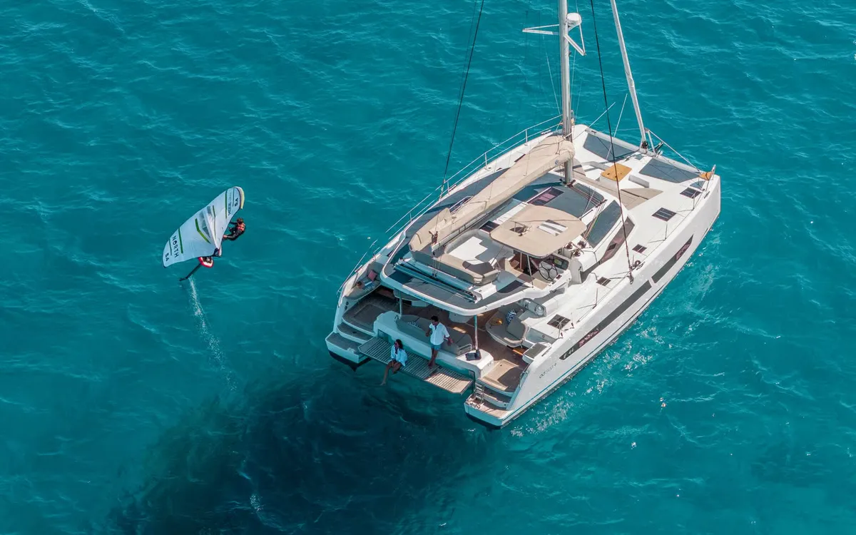 Fountaine Pajot FP44: Catamaran met windsurfer op zee