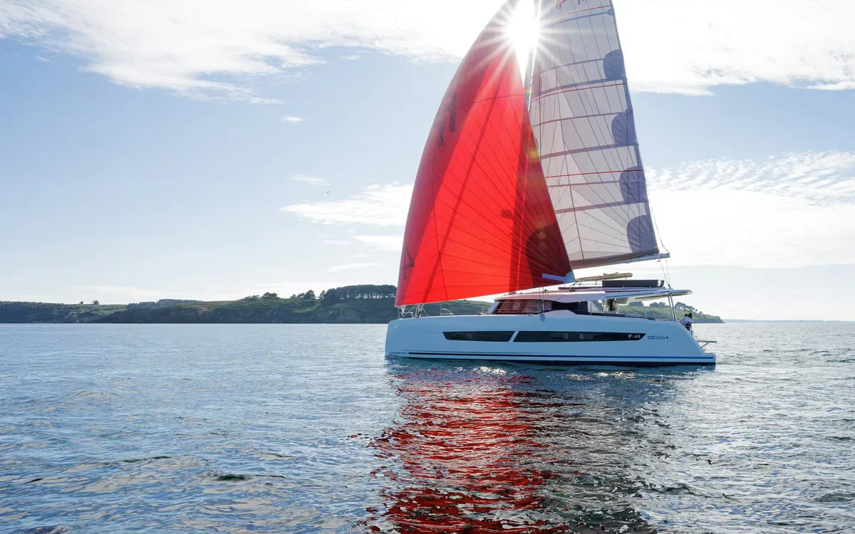 Fountaine Pajot FP48: Catamaran zeilend met rode spinnaker