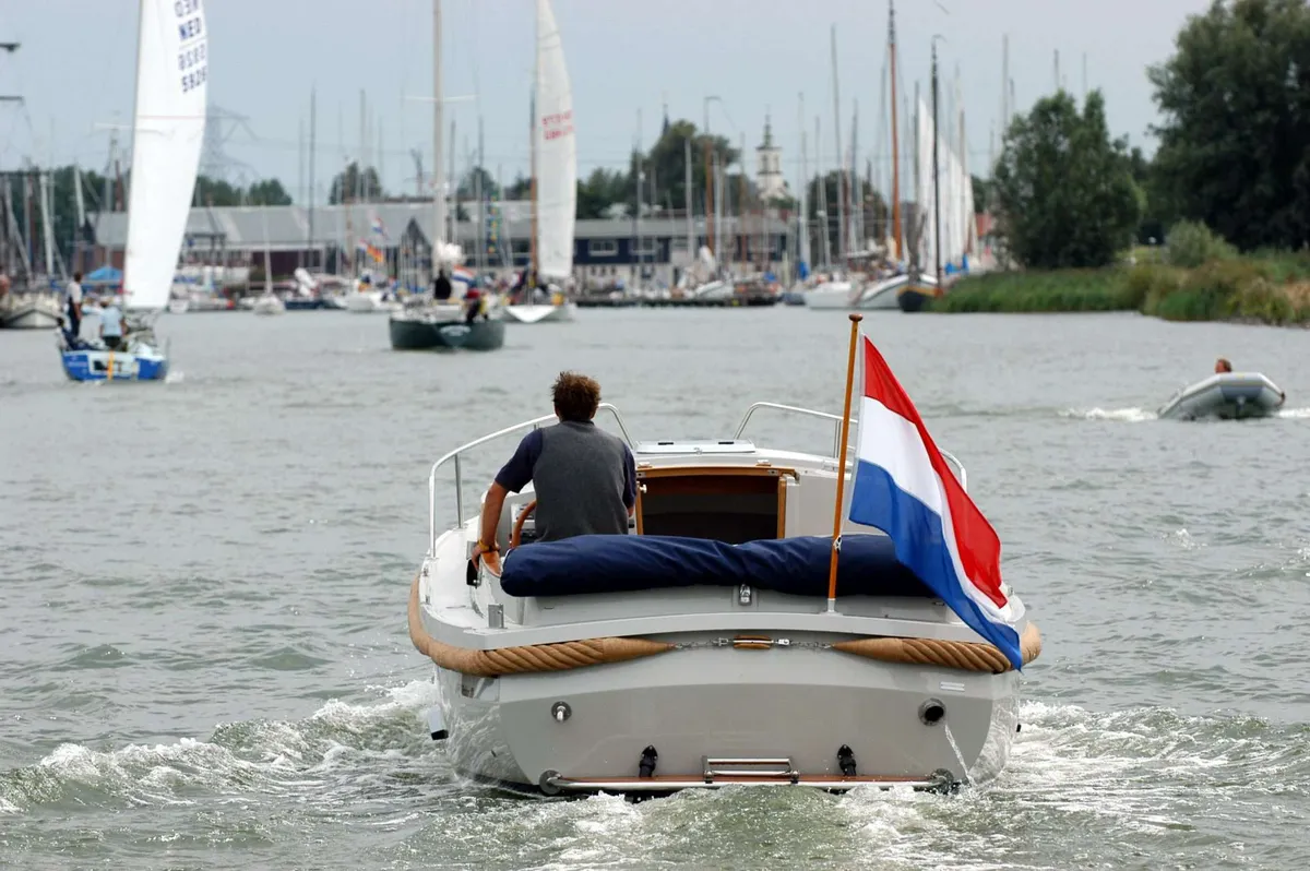 ONJ Motorboten Workboat 770: Boot varend op water met vlag